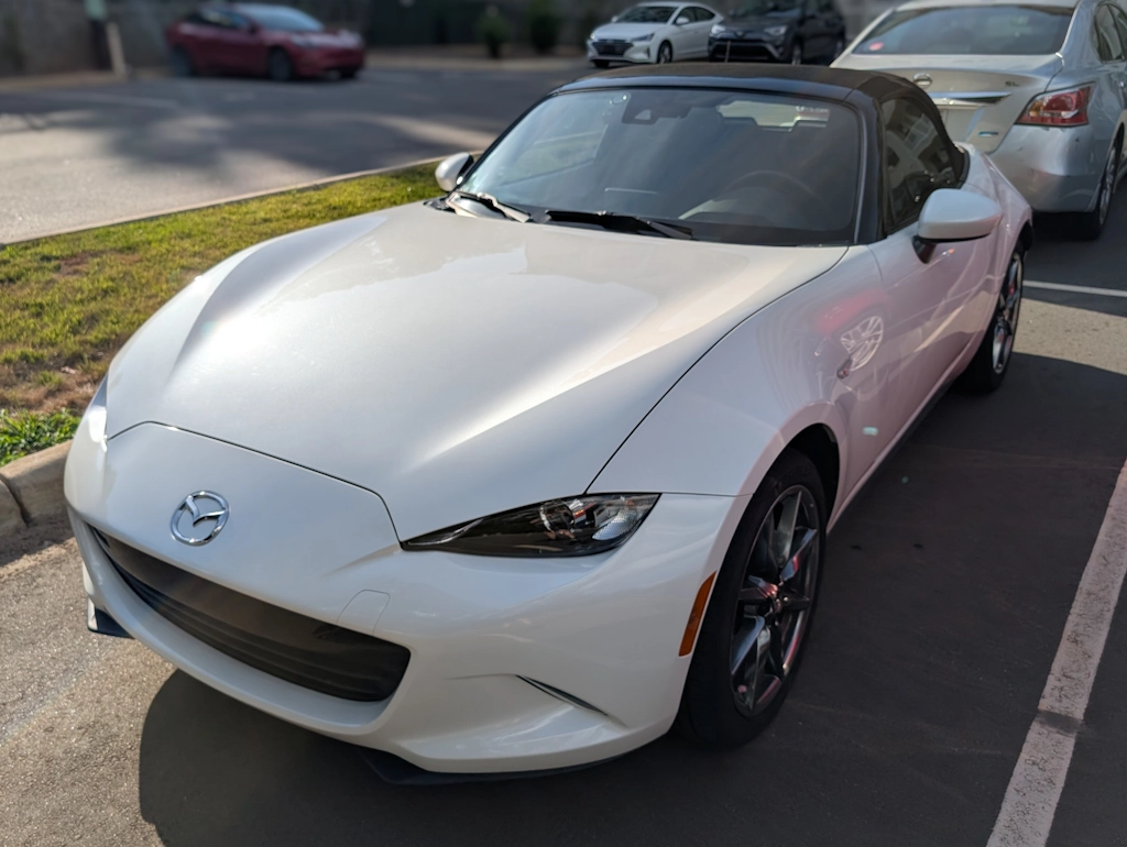 Miata in parking lot close to sunset